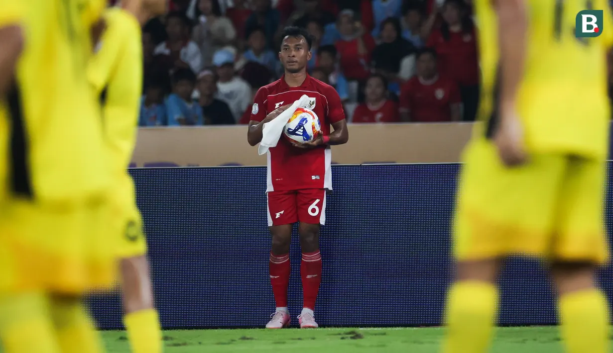 Pemain Timnas Indonesia U-23, Robi Darwis mengelap bola sebelum melakukan lemparan ke dalam saat laga Grup A Piala AFF U-23 2025 melawan Malaysia di Stadion Utama Gelora Bung Karno (SUGBK), Senayan, Jakarta, Senin (21/07/2025). (Bola.com/Abdul Aziz)