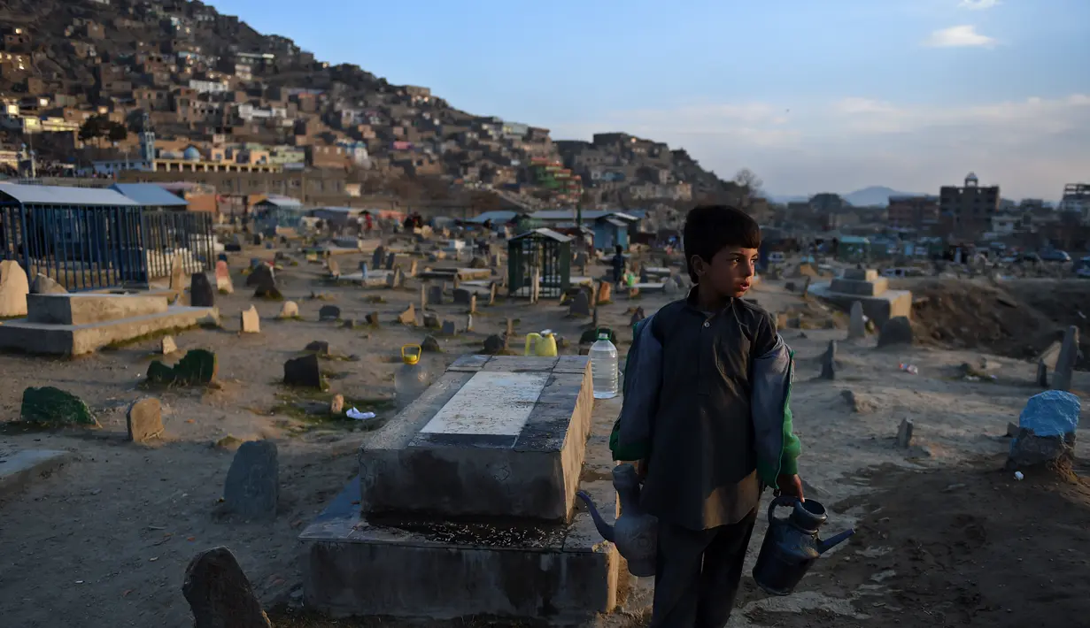 Afghan Zilgai (9), bocah penjual air ketika mencari pelanggan di pemakaman Kart-e-Sakhi, Kabul, 20 Februari 2016. Anak sulung dari 8 bersaudara itu menjual air dari fajar hingga senja kepada para peziarah (AFP PHOTO/Wakil KOHSAR)