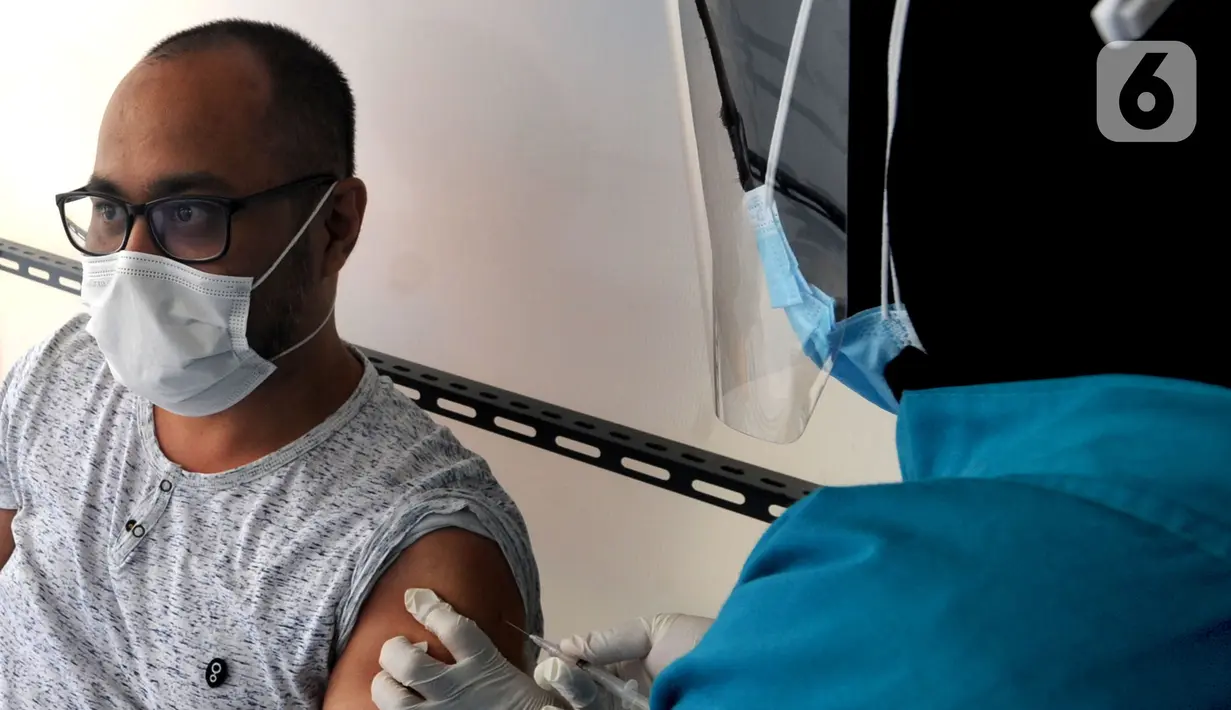 Dokter menyuntikkan vaksin virus corona COVID-19 produksi Sinovac saat kegiatan vaksinasi di Puskemas Jagakarsa, Jakarta Selatan, Kamis (14/1/2020). Sejumlah Puskesmas di Jabodetabek mulai melakukan vaksinasi COVID-19 pada hari ini. (merdeka.com/Arie Basuki)