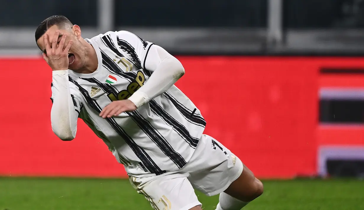 Cristiano Ronaldo memegang wajahnya saat terjatuh di area penalti dalam laga pekan ke-14 Liga Italia antara Juventus vs Fiorentina di Allianz Stadium Turin, Rabu dinihari WIB (23/12/2020). Ronaldo dkk menelan kekalahan pertama di Liga Italia 0-3 saat menjamu Fiorentina. (Marco BERTORELLO/AFP)