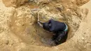 Seorang penambang emas menggali tanah di sebuah situs penambangan di kota Betare Oya, Kamerun (4/4).  (AFP Photo/Reinnier Kaze)
