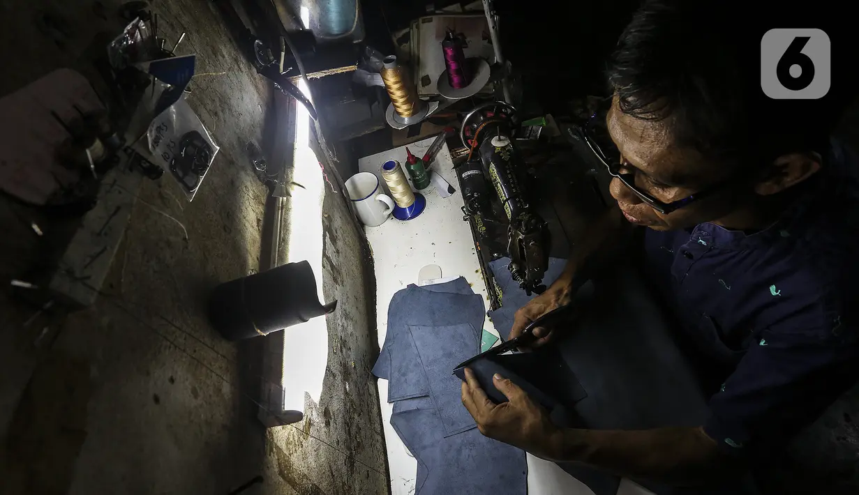 Pekerja menyelesaikan pembuatan sepatu di industri rumahan daerah Kuningan, Jakarta Selatan, Jumat (22/1/2020). Pemilik industri sepatu rumahan ini mengaku selama pandemi omzet berkurang hingga 70 persen. (Liputan6.com/Johan Tallo)