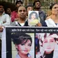 Fans aktris Bollywood Sridevi Kapoor memegang poster sang mendiang saat berdiri di luar rumah jelang pemakamannya, Mumbai, India, Rabu (28/2). (AP Photo/Rafiq Maqbool)