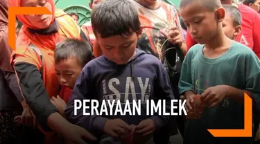 Puluhan masyarakat Pademangan Jakarta Utara menunggu pembagian Ang Pao dari warga Tionghoa yang merayakan Imlek. Pembahgian Ang Pao dikwal anggota Polsek pademangan Jakarta Utara