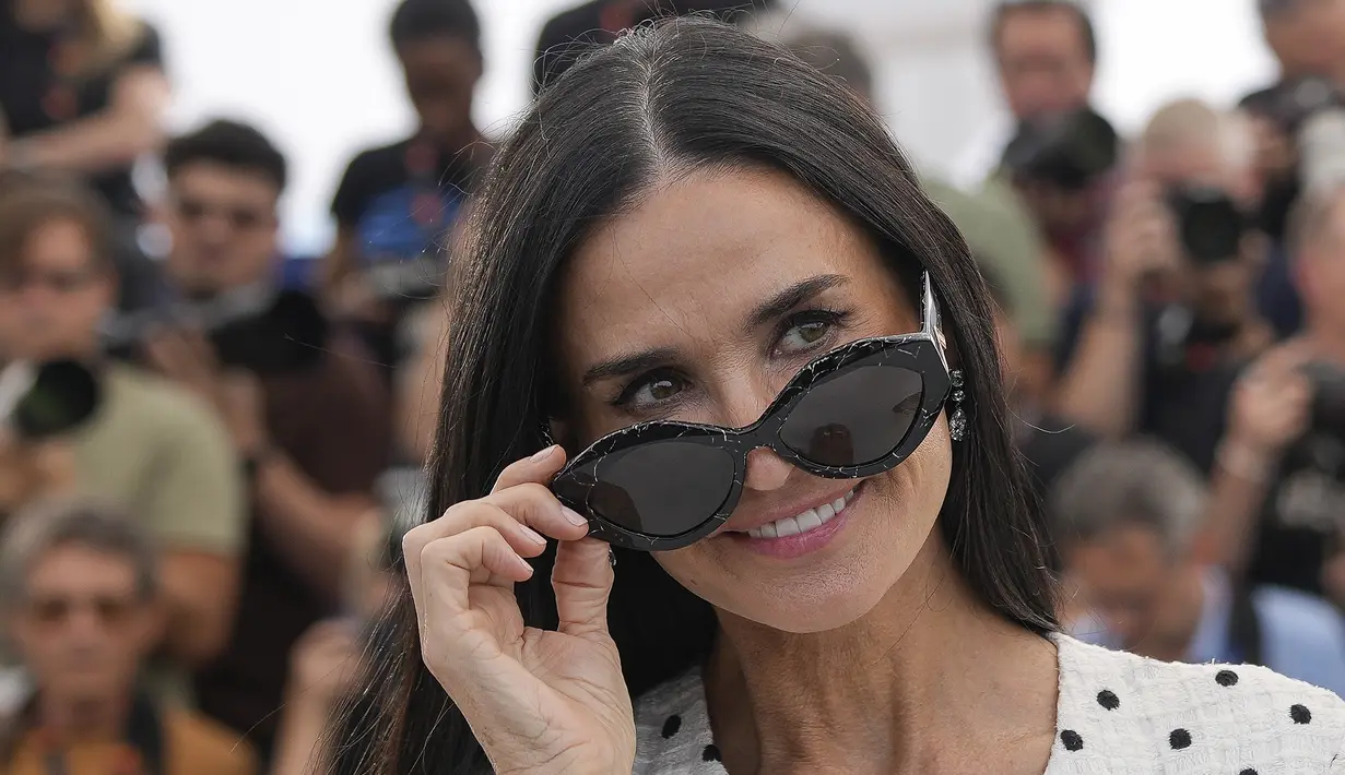 Demi Moore melengkapi busana klasik tersebut dengan anting-anting berlian yang menjuntai, dua cincin berlian, dan kacamata hitam untuk menyempurnakan penampilannya. (Photo by Andreea Alexandru/Invision/AP)