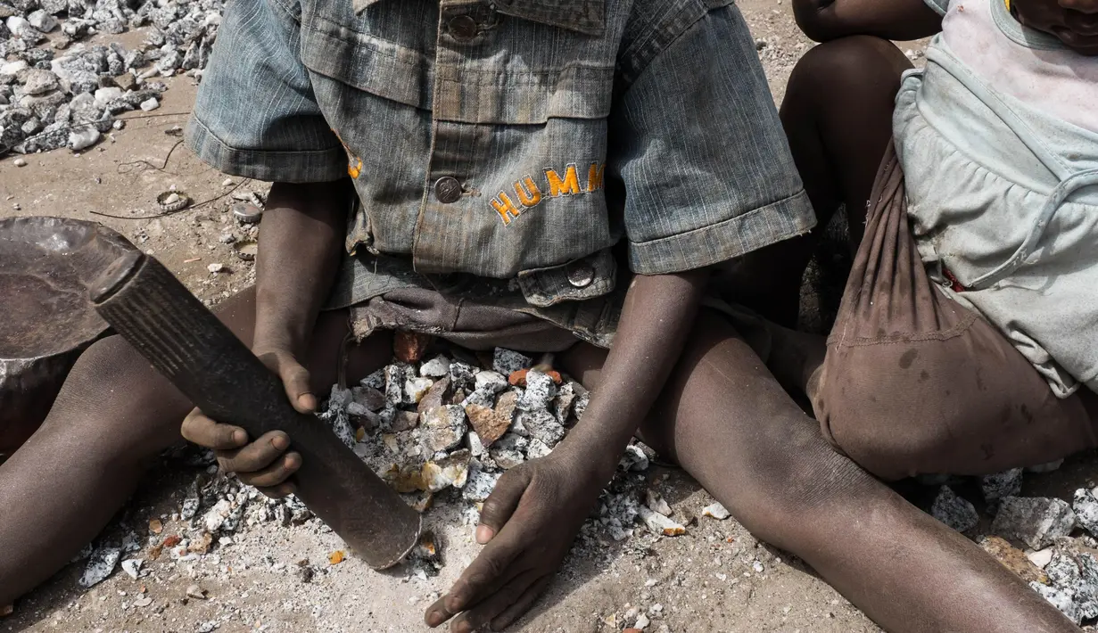 Seorang bocah tampak memecahkan batu di sebuah tambang di Ouagadougou, Burkina Faso, 21 Desember 2015. Pada 12 Juni, Organisasi perburuhan Internasional melakukan aksi menentang mempekerjakan anak dibawah umur. (NABILA EL Hadad / AFP)