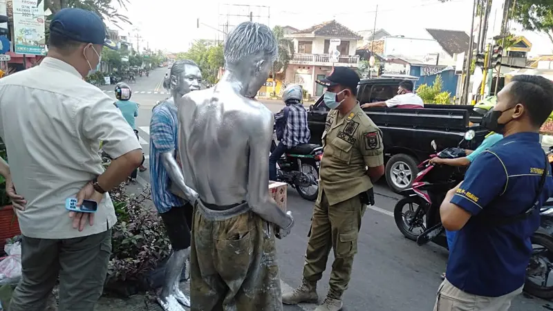 Petugas Satpol PP Kabupaten Rembang ketika menertibkan manusia perak di lampu traffic light Eks Stasiun Jl Kartini, Rembang.