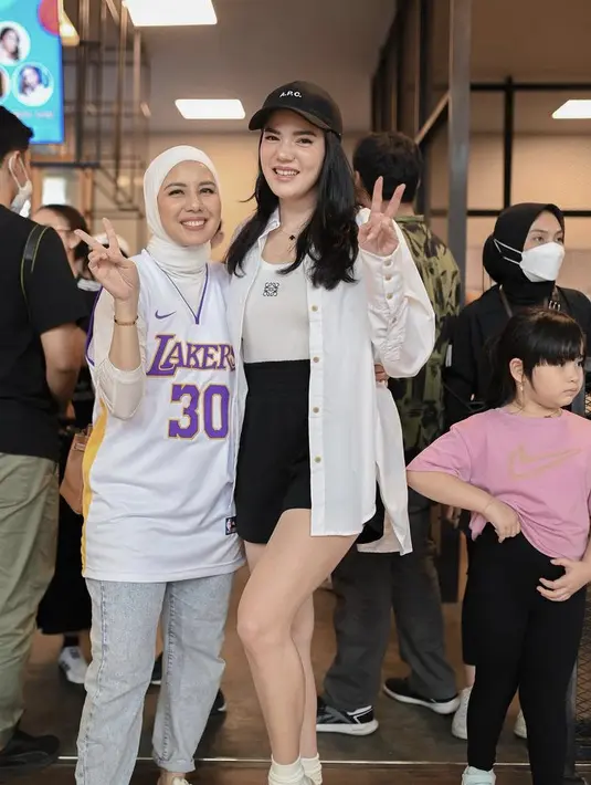 Alice Norin pun tampil monokrom, mengenakan atasan tank top yang serasi dengan outer kemeja putihnya. Dipadukan mini skirt hitam dan topi capnya.credit: Instagram (@tya_ariestya)