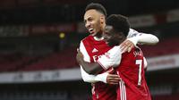 Pemain Arsenal, Bukayo Saka, merayakan gol bersama Pierre-Emerick Aubameyang, usai mencetak gol ke gawang Newcastle United pada laga Liga Inggris di Stadion Emirates, Senin (18/1/2021). Arsenal menang dengan skor 3-0. (Catherine Ivill/Pool via AP)