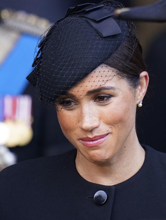 Ekspresi Meghan Markle usai mengikuti prosesi persemayaman Ratu Elizabeth II di Westminster Hall di London (14/9/2022). Meghan Markle tampil mengenakan sepasang anting-anting berlian dan mutiara. (AFP/Pool/Danny Lawson)