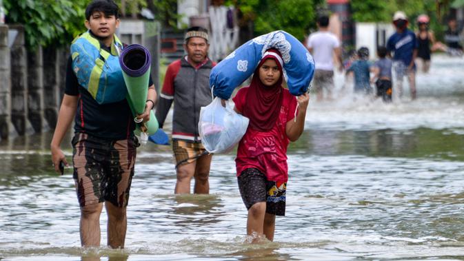 Warga melintasi lingkungan yang banjir setelah tiga hari diguyur hujan lebat di Banda Aceh, Aceh, Sabtu (9/5/2020). Banjir akibat intensitas hujan tinggi tersebut mengakibatkan sebagian besar kawasan di ibu kota Provinsi Aceh ini digenangi air. (Photo by CHAIDEER MAHYUDDIN/AFP)
