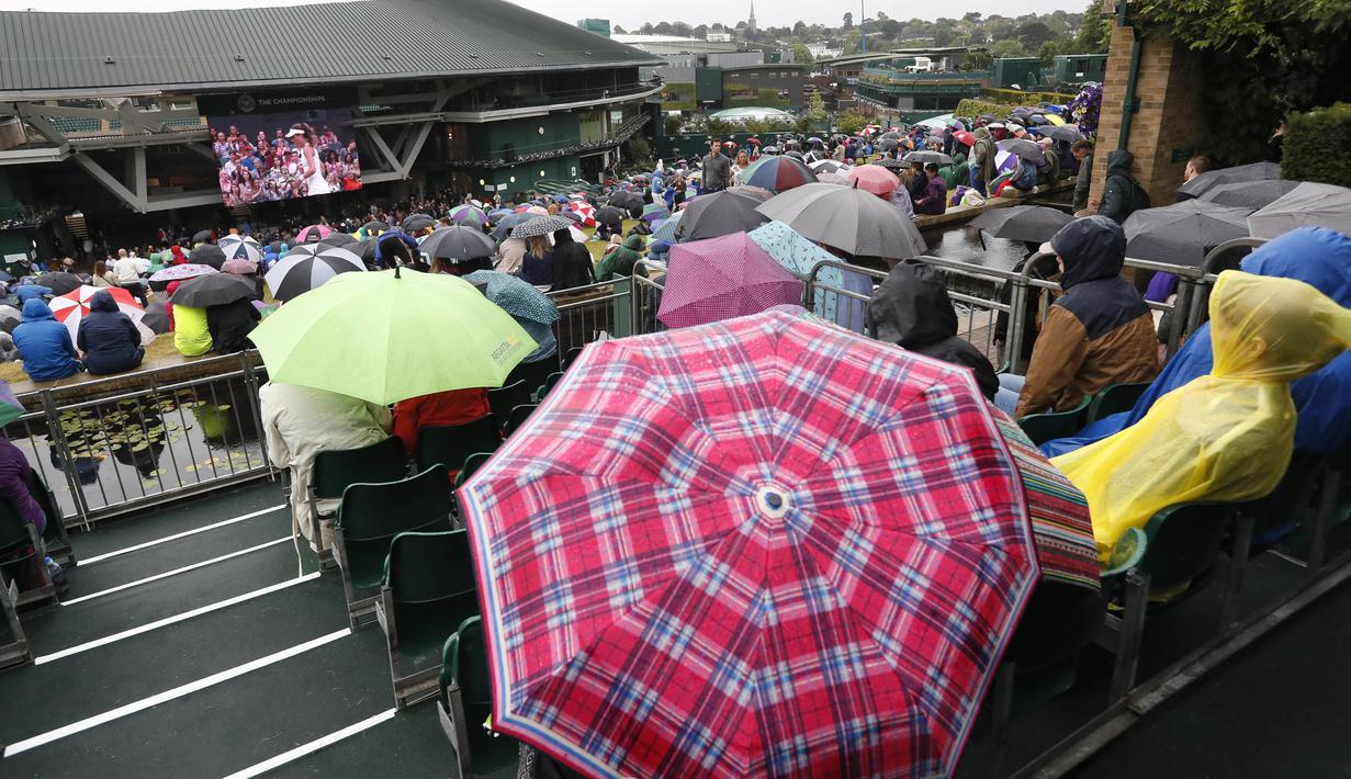Warna-warni payung yang digunakan penonton saat menyaksikan laga tenis Wimbledon dari layar di The All England Lawn Tennis Club, London, (11/7/2017). (AP/Kirsty Wigglesworth)