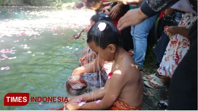 Siswa MI Darul Ulum mandi bunga mawar di Blumbang Macari, Jumat (13/4/2018). Mereka mengikuti prosesi Jamasan Sukmo Pusoko Rogo. (FOTO: Ferry/TIMES Indonesia)