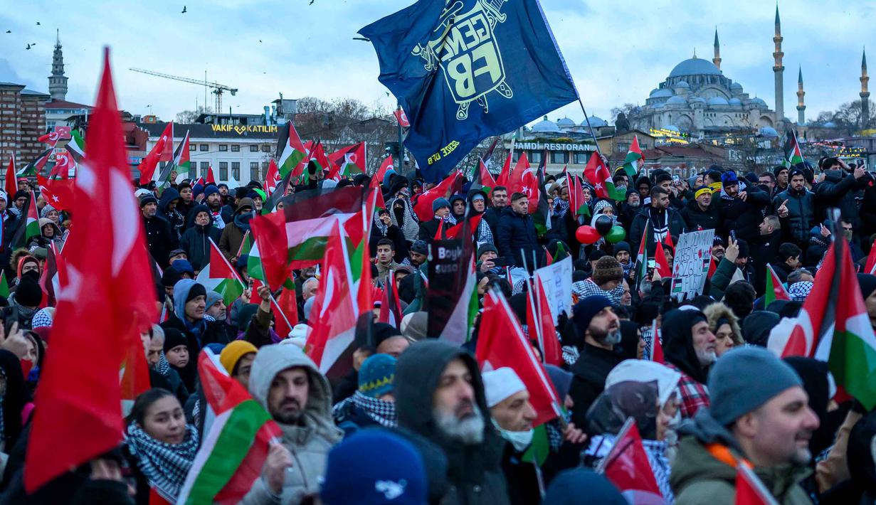 Sementara, 171.232 lainnya mengalami luka, baik ringan maupun berat. Tampak dalam foto, orang-orang mengibarkan bendera Turki dan bendera Palestina saat mereka berdemonstrasi sebagai bentuk solidaritas dengan rakyat Palestina di tengah perang yang sedang berlangsung antara Israel dan kelompok Hamas di wilayah Gaza, di Jembatan Galata, Istanbul, Turki pada 1 Januari 2026. (Yasin AKGUL/AFP)