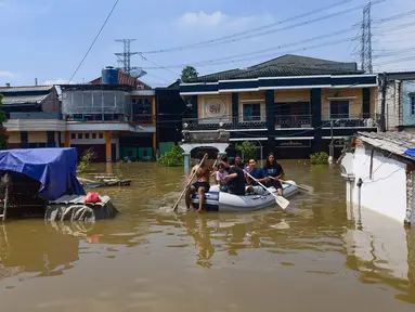 Para pemuda mengevakuasi warga saat banjir menggenangi kawasan RT 02/06, Kelurahan Petir, Kota Tangerang, Banten, Selasa (8/7/2025). (merdeka.com/Arie Basuki)