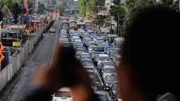 Salah seorang pejalan kaki saat mengabadikan kemacetan di Jl MH Thamrin, Jakarta, Kamis (18/12/2014). (Liputan6.com/Faizal Fanani)