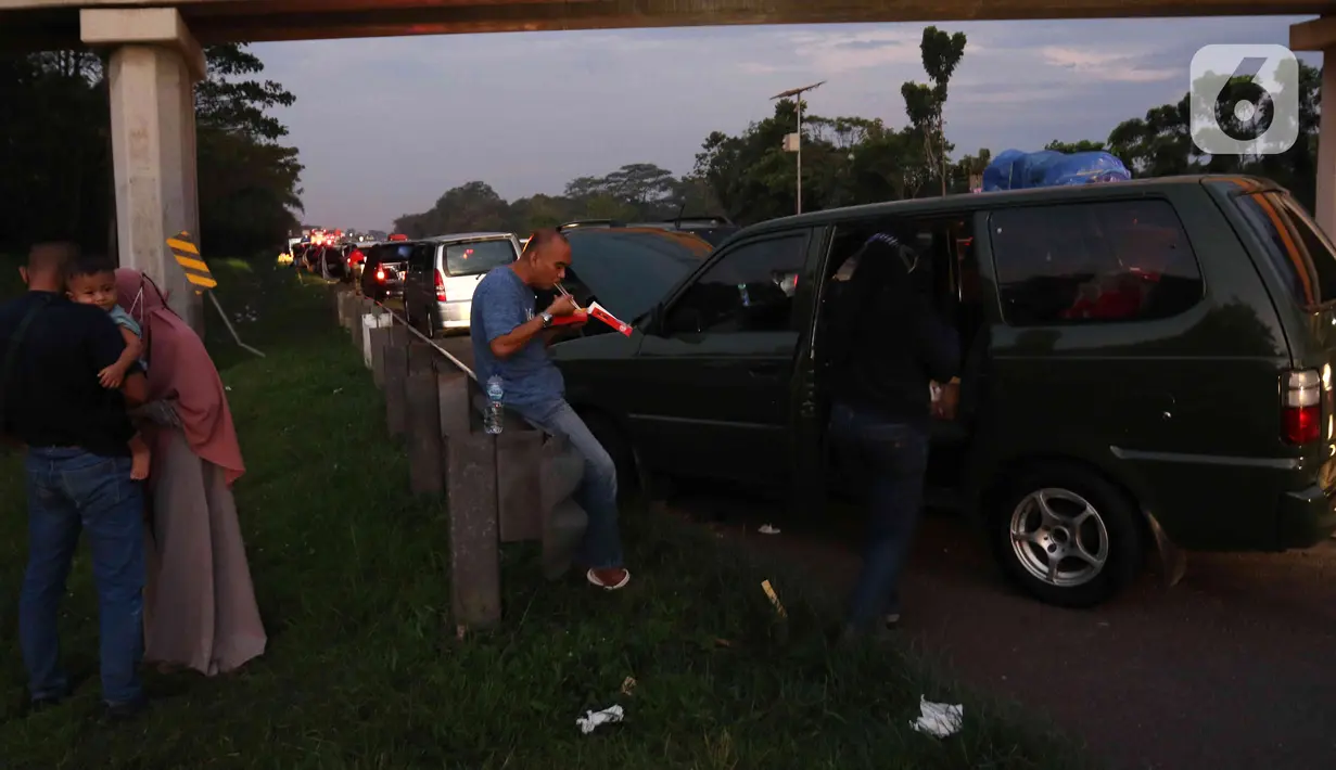 <p>Sejumlah pemudik berbuka puasa Ramadhan sambil beristirahat di KM 102 ruas Tol Cikopo-Palimanan, Subang, Jawa Barat, Kamis (28/4/2022). Padatnya sejumlah rest area di sepanjang jalan tol Trans Jawa membuat pemudik memanfaatkan bahu jalan untuk berbuka puasa dan istirahat sejenak. (Liputan6.com/Herman Zakharia)</p>