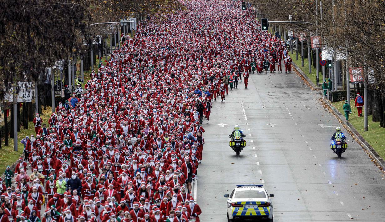 Salah satu peserta mengatakan bahwa lari tersebut merupakan cara untuk menyebarkan energi positif di hari Natal. Tampak dalam foto, ribuan pelari yang mengenakan kostum Santa Claus berpartisipasi dalam edisi ke-14 lomba Santa Claus, sebuah lari santai sejauh 4,5 km melalui jalan-jalan Madrid pada Minggu 21 Desember 2025. (OSCAR DEL POZO/AFP)