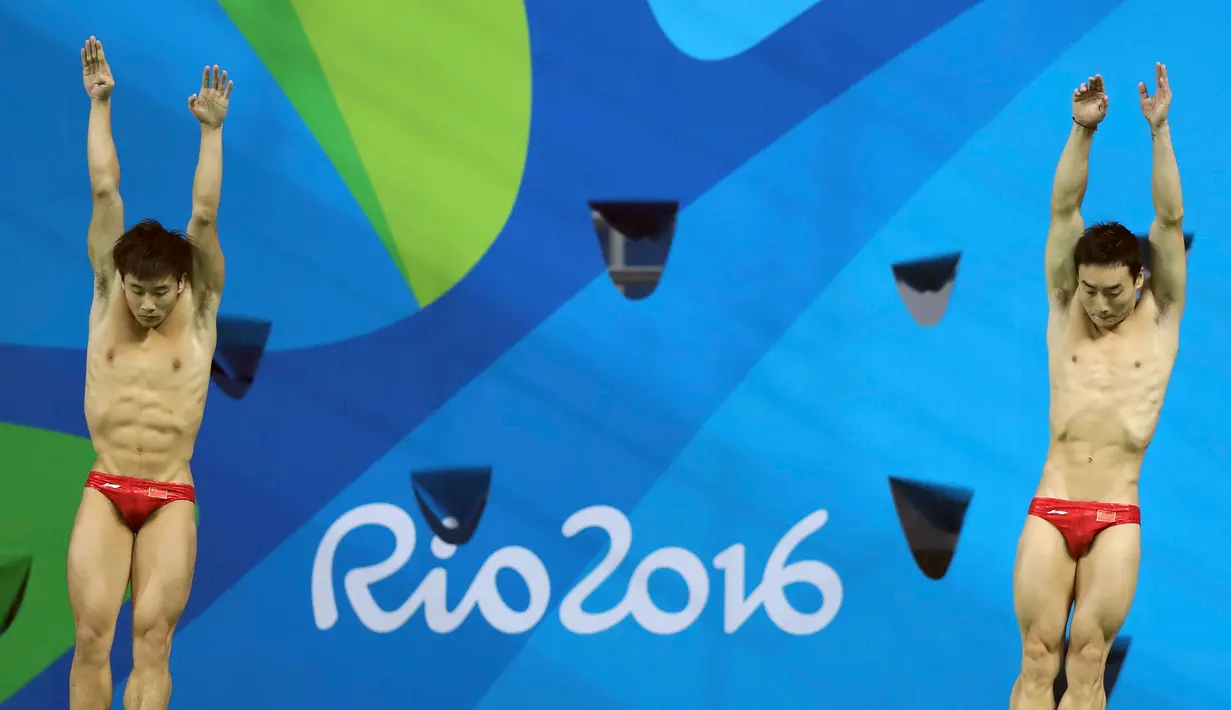 Atlet Tiongkok, Atlet dan Qin Kai saat mengikuti loncat indah sinkronisasi 3 m pria pada Olimpiade 2016 di Brasil, (10/8). Dalam cabang olahraga ini setiap negara harus memiliki 2 peserta.  (REUTERS/Antonio Bronic)