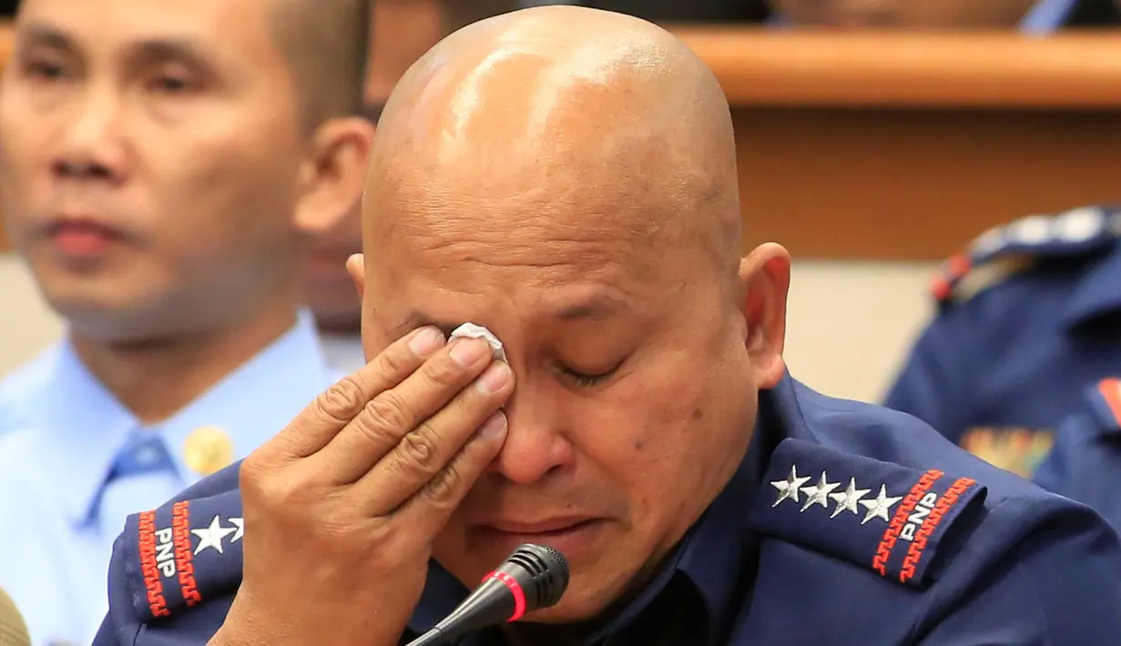 Kepala Polisi Nasional Filipina Ronald Dela Rosa menyeka air matanya disela sidang dengar pendapat di Manila, Rabu (23/11). Tangisan itu muncul setelah mendengar kesaksian tentang keterlibatan polisi dalam peredaran narkoba. (REUTERS/Romeo Ranoco)