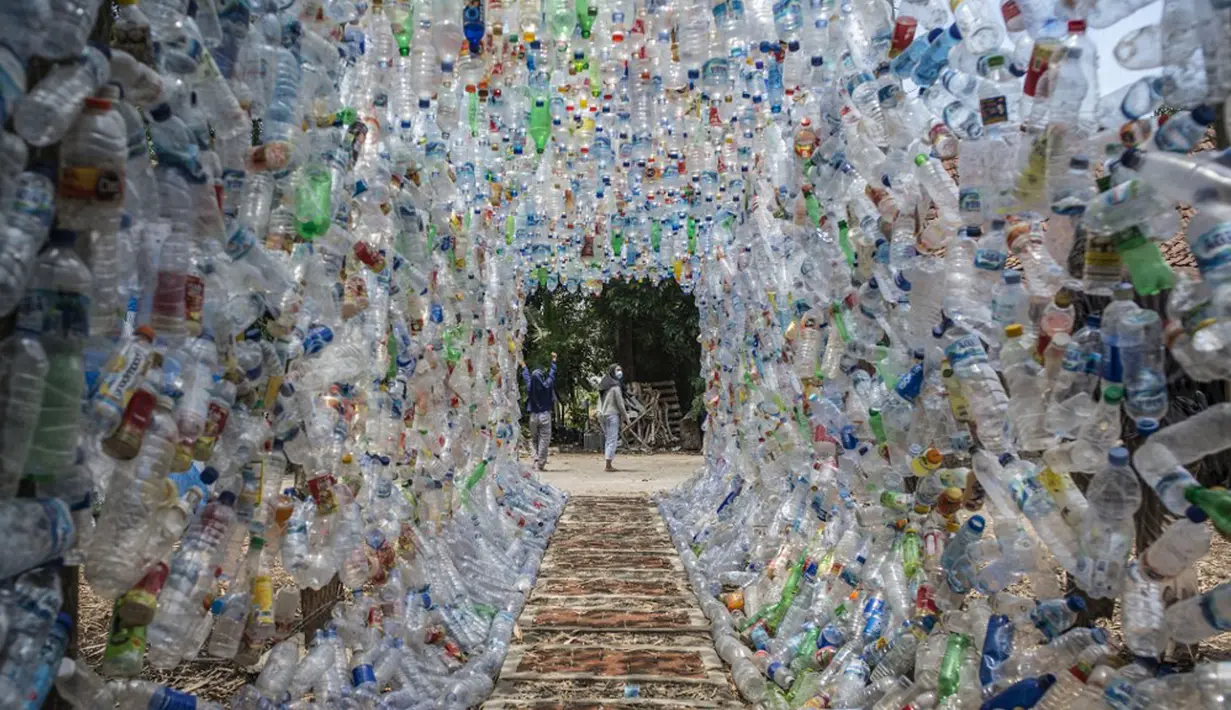 Aktivis Ecological Observation and Wetland Conservation (Ecoton) usai membuat instalasi yang terbuat dari sampah plastik di Gresik, Jawa Timur, 17 September 2021. Instalasi tersebut di antaranya terbuat dari 4.444 botol. (JUNI KRISWANTO/AFP)