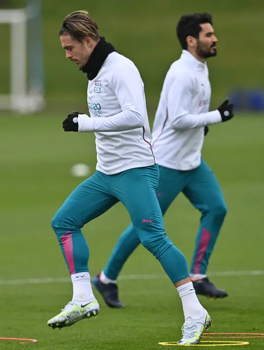 Gelandang Manchester City, Jack Grealish (kiri) mengambil bagian dalam sesi latihan di tempat latihan Manchester City di Manchester, barat laut Inggris (4/4/2022). Man City akan bertanding melawan Atletico Madrid pada leg pertama perempat final Liga Champions di Etihad Stadium. (AFP/Paul Ellis)