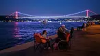 Orang-orang menikmati malam di sebelah pantai Bosphorus ketika jembatan Fatih Sultan Mehmet terlihat di Istanbul (6/7/2020). Jembatan Fatih Sultan Mehmet, yang dikenal dengan sebutan Jembatan Bosporus Kedua, adalah sebuah jembatan di Istanbul, Turki yang melintasi selat Bosporus. (AFP/Ozan Kose)
