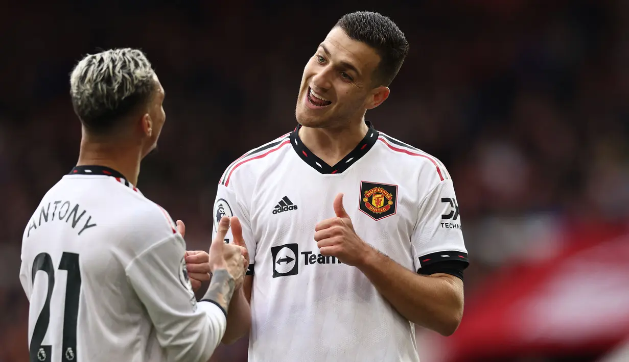 Pemain Manchester United, Diogo Dalot merayakan gol kedua tim bersama rekannya, Antony saat laga lanjutan Liga Inggris 2022/2023 melawan Nottingham Forest di City Ground, Nottingham, Senin (17/04/2023) WIB. Ini merupakan gol perdana Dalot di Liga Inggris. (AFP/Darren Stapels)