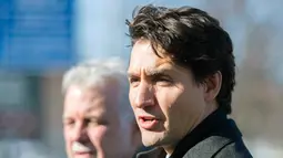PM Kanada, Justin Trudeau menghadiri pemakaman tiga dari enam korban penembakan di Masjid Quebec di Montreal Olympic, Kamis (2/2). PM Kanada bersama ribuan warga ikut menunjukkan rasa berkabungnya di pemakaman. (Graham Hughes/The Canadian Press via AP)