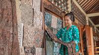 Ilustrasi perempuan sedang melihat-lihat kain batik/copyright shutterstock.com/Odua Images
