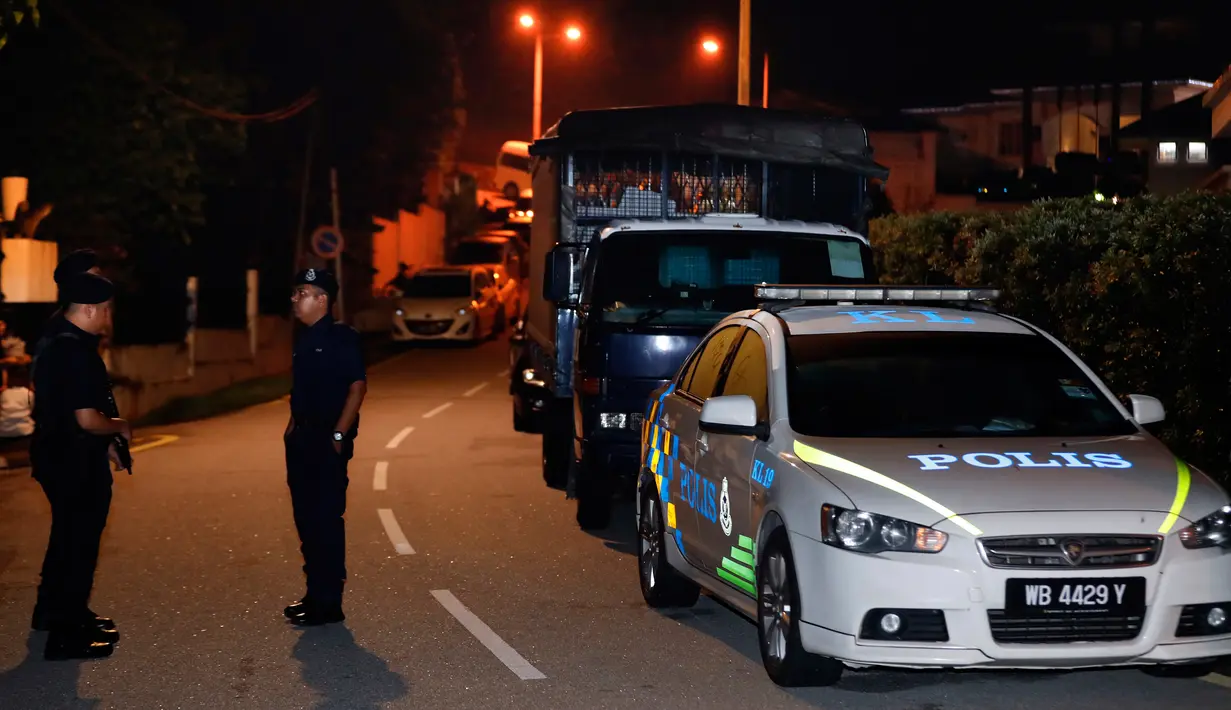 Aparat kepolisian berjaga di depan rumah mantan Perdana Menteri Malaysia, Najib Razak di Kuala Lumpur, Rabu (16/5). Tim kepolisian yang menumpang 10 mobil melakukan penggeledahan terkait dugaan pencucian uang di kediaman Najib. (AP/Vincent Thian)