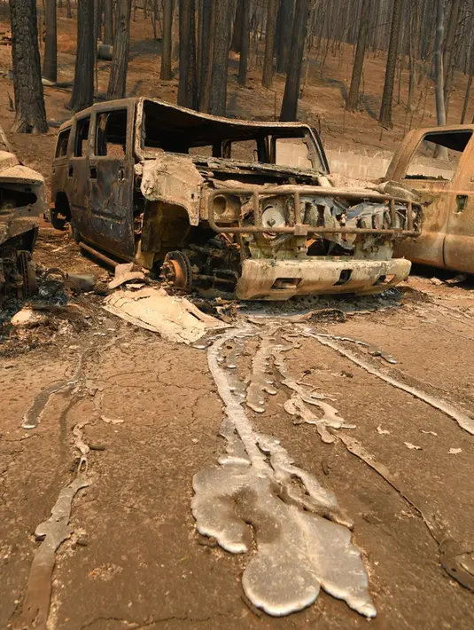 Logam cair mengalir menjauh dari kendaraan Hummer yang terbakar saat kebakaran Dixie di pusat Kota Greenville, California, Amerika Serikat, 5 Agustus 2021. Kebakaran Dixie menjalar ke pemukiman di Greenville. (JOSH EDELSON/AFP)