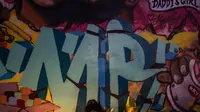 Seorang perempuan meletakkan lilin di depan mural bergambar Kobe Bryant dan putrinya Gianna Bryant di Los Angeles, Senin (27/1/2020). Pemain basket legendaris NBA Kobe Bryant bersama putrinya, Gianna yang berusia 13 tahun meninggal dunia dalam kecelakaan helikopter pada Senin (27/1). (Apu GOMES/AFP)