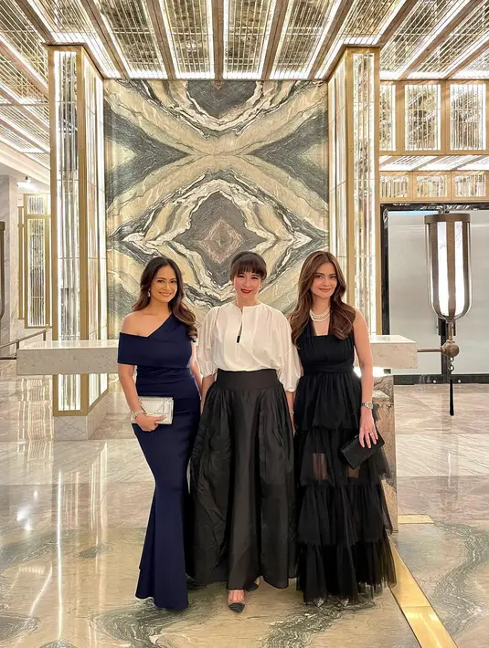 Gaya keduanya berpose dalam balutan gaun malam yang elegan. Ersa Mayori tampil cantik mengenakan dress biru dengan lengan yang asimetris, sedangkan Cut Tari tampil cantik dengan dress hitam tanpa lengan. Di tengah keduanya ada Novita Angie yang tak kalah memesona dengan padu padan atasan lengan panjang berwarna putih dipadu rok panjang hitam. [Foto: Instagram/cuttaryofficial]