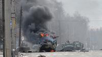 Foto mobil pengangkut personel tentara Rusia terbakar di Kharkiv, Ukraina, yang diambil pada 27 Februari 2022. (dok. Sergey BOBOK/ AFP)