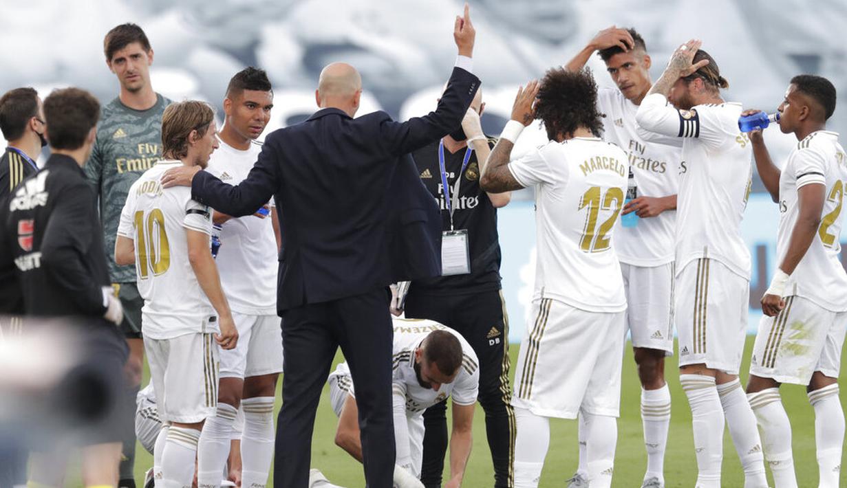 Pelatih Real Madrid, Zinedine Zidane, memberikan arahan kepada anak asuhnya saat melawan Eibar pada laga La Liga di Estadio Alfredo Di Stefano, Senin (15/6/2020). Real Madrid menang 3-1 atas Eibar. (AP/Bernat Armangue)