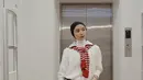 Tampil kasual dengan kerudung turban hitam, Anselma memadukannya dengan inner halter neck putih serta kemeja putih lengan panjang dan menyematkan sweater merah di pundak. Ia memilih mengenakan celana denim dan sepatu hitamnya.  [@ansellmaputri]