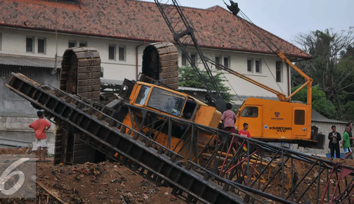 Crane untuk memasang turap di bantaran Kali Kampung Pulo jatuh ke Sungai Ciliwung (1/10/15) dan menimpa gubuk. Akibatnya, seorang warga RT15/10 Kelurahan Bukit Duri, Jakarta Selatan harus mendapatkan perawatan medis. (Liputan6.com/Gempur M Surya)