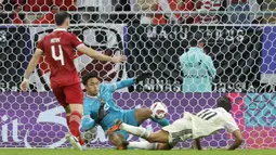 Kiper Timnas Indonesia, Ernando Ari Sutaryadi (tengah) berhasil memblok sundulan striker Timnas Irak, Mohanad Ali pada laga pertama Grup D Piala Asia 2023 Qatar di Ahmad bin Ali Stadium, Al-Rayyan, Doha, Senin (15/1/2024). Ini merupakan momen offside yang dipermasalahkan pihak Timnas Indonesia sebelum pemain Irak, Osama Rashid, berhasil mencetak gol. (AFP/Karim Jaafar)