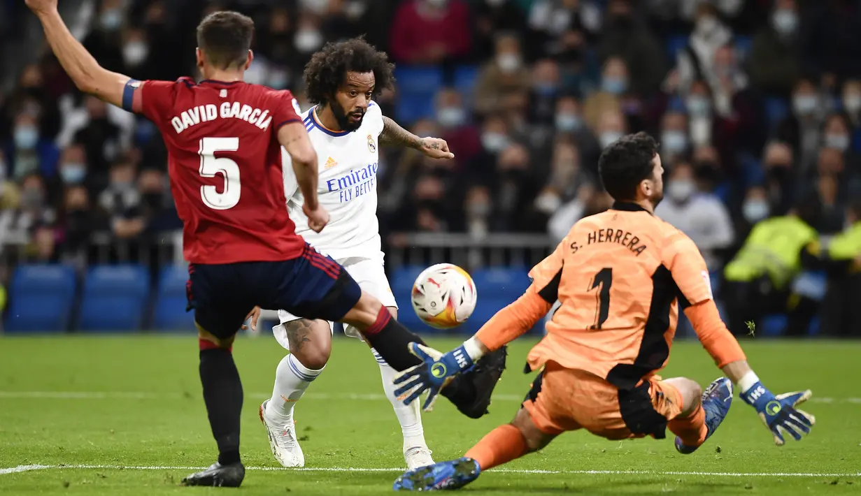 Pemain Real Madrid Marcelo (tengah) diblok oleh pemain Osasuna David Garcia (kiri) dan kiper Sergio Herrera pada pertandingan La Liga Spanyol di Stadion Santiago Bernabeu, Madrid, Spanyol, 27 Oktober 2021. Pertandingan berakhir 0-0. (AP Photo/Jose Breton)