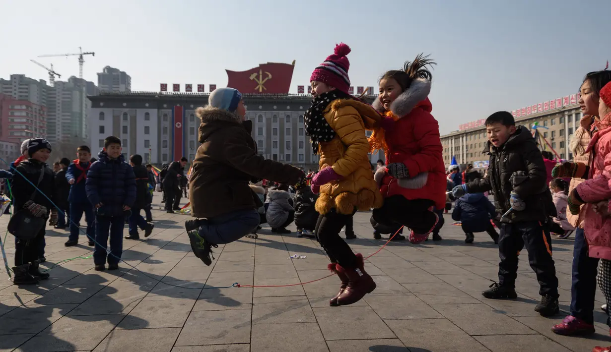 Sejumlah anak bermain lompat tali saat merayakan hari libur Tahun Baru Imlek di alun-alun Kim Il Sung di Pyongyang, Korea Utara (16/2). Dalam perayaan Imlek di Korea Utara ini tidak terlihat ornamen dan aksesoris khas Tionghoa. (AFP Photo/Kim Won-Jin)