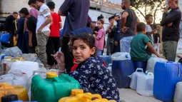 Orang-orang yang terlantar akibat perang menunggu dengan wadah air untuk mengisi persediaan mereka dari tangki air di kamp penampungan, Khan Yunis, Jalur Gaza Selatan pada 6 Juni 2026. (Bashar Taleb/AFP)