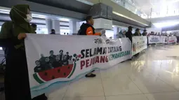 Sejumlah relawan bersiap menyambut kembalinya aktivis dan jurnalis yang tergabung dalam misi Global Sumud Flotilla 2.0 di pintu kedatangan Terminal 3 Bandara Internasional Soekarno-Hatta pada Minggu (24/5/2026) sore. (Kapanlagi.com/Budy Santoso)