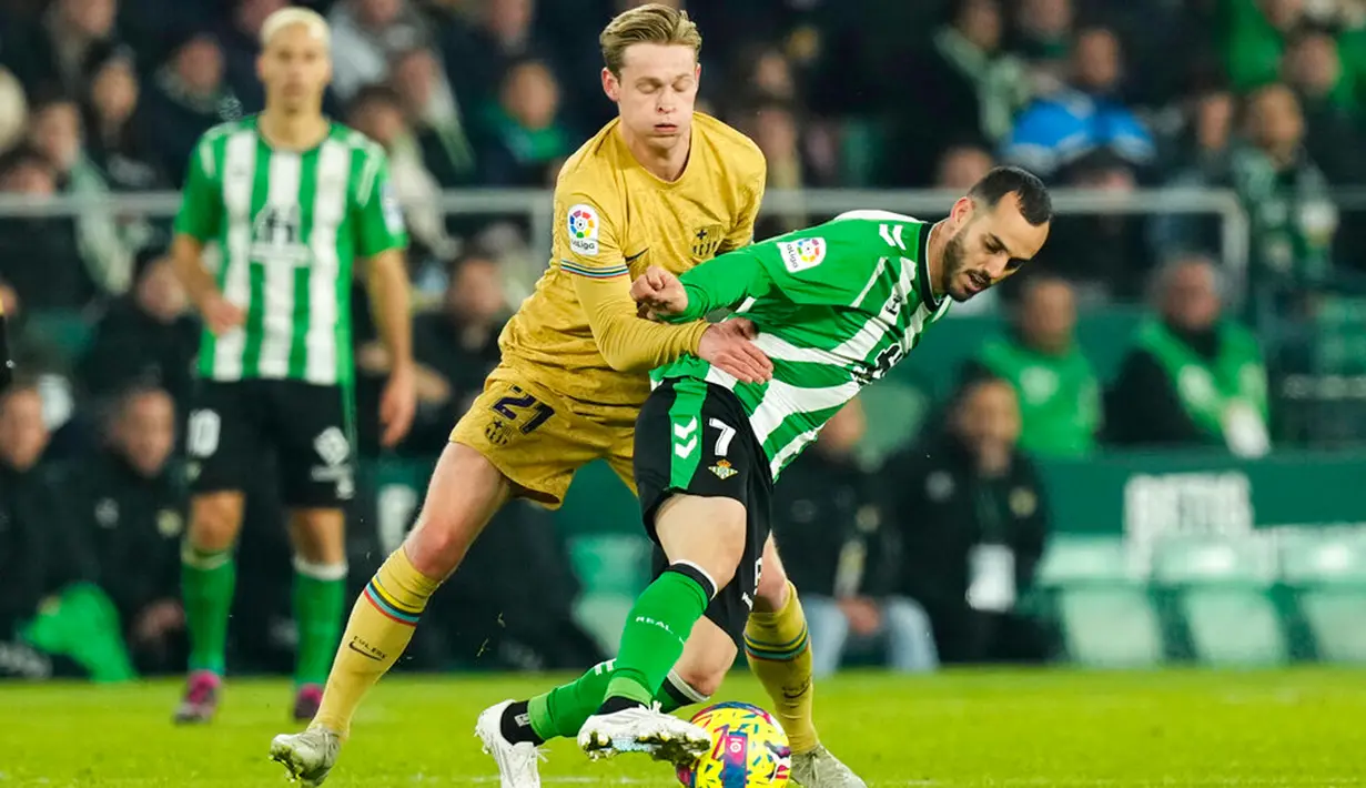 Pemain Real Betis Juanmi (kanan) berebut bola dengan pemain Barcelona Frenkie de Jong pada pertandingan sepak bola Liga Spanyol di Stadion Benito Villamarin, Seville, Spanyol, 1 Februari 2023. Barcelona genap mengoleksi 50 poin dan unggul 8 poin dari Real Madrid usai menang 2-1 atas Real Betis pada lanjutan Liga Spanyol. (AP Photo/Jose Breton)