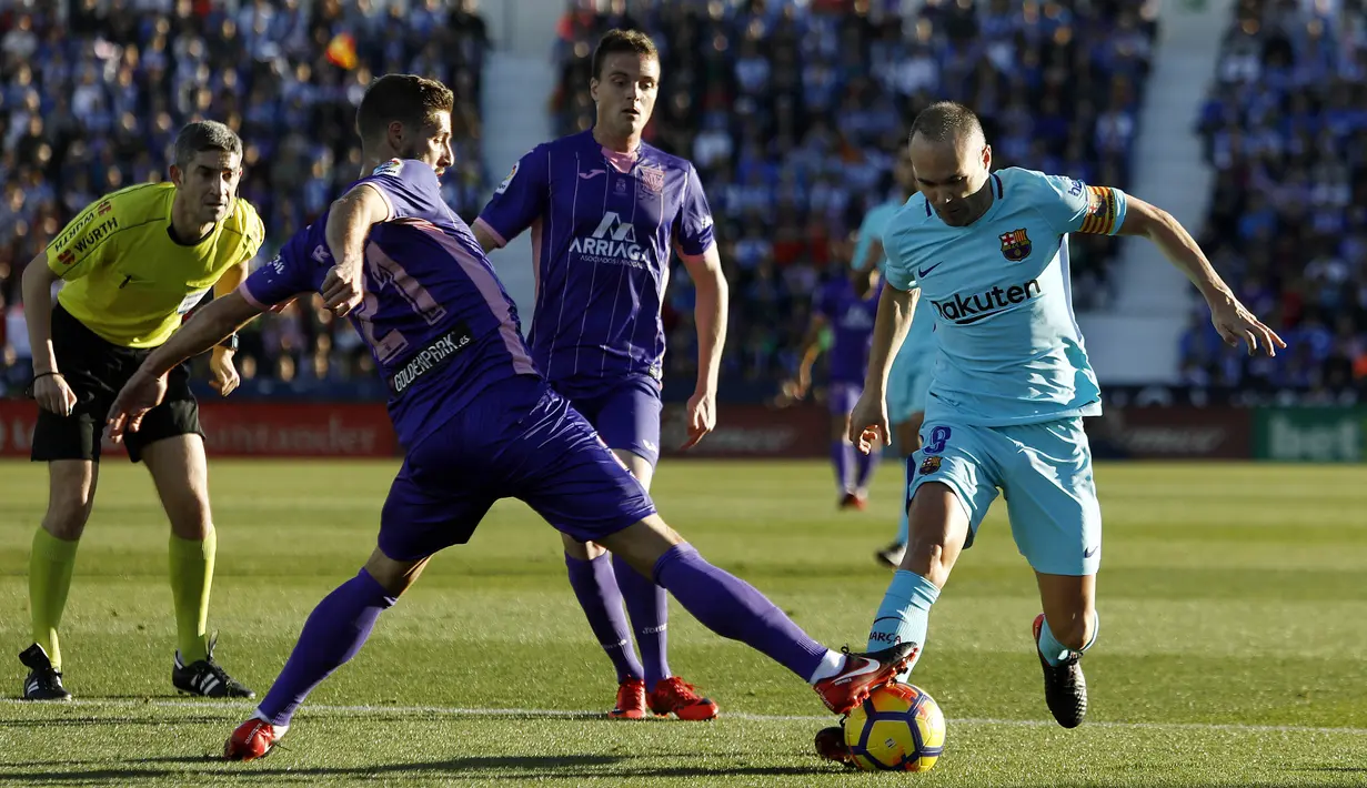 Gelandang Barcelona, Andres Iniesta, berusaha melewati gelandang Leganes, Ruben Perez, pada laga La Liga Spanyol di Stadion Butarque, Leganes, Sabtu (18/11/2017). Leganes kalah 0-3 dari Barcelona. (AFP/Oscar Del Pozo)