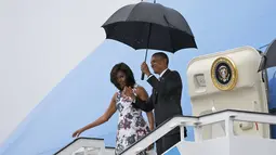 Presiden AS Barack Obama dan istrinya Michelle saat turun dari pesawat Air Force One setibanya di Bandara Internasional Havana, Kuba, Minggu (20/3). Kunjungan Obama ini yang pertama dilakukan seorang presiden AS sejak 88 tahun lalu. (REUTERS/stringer)