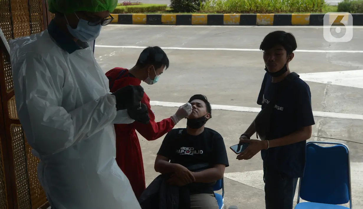 Petugas melakukan swab test antigen kepada pemudik saat arus balik Lebaran di Terminal Pulogebang, Jakarta, Jumat (21/5/2021). Pada hari ini, ada tiga pemudik terindikasi positif COVID-19. (merdeka.com/Imam Buhori)
