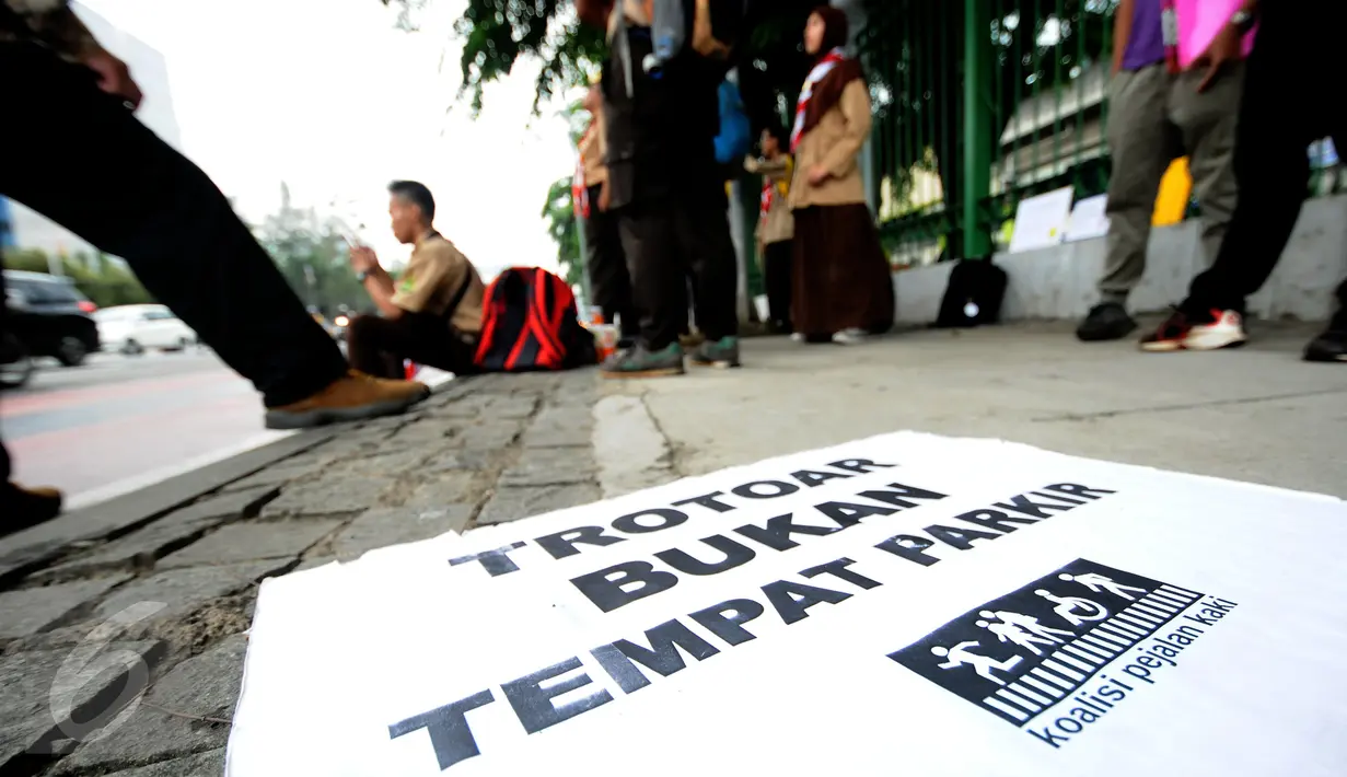 Salah satu tulisan yang dikampanyekan oleh anggota Pramuka yang tergabung dalam Askara saat melakukan aksi peduli pedestrian di sekitar Jalan Medan Merdeka Timur, Jakarta, Jumat (17/3). (Liputan6.com/Helmi Fithriansyah)
