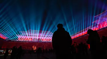 Pengunjung menyaksikan dinding gerbang utama Wu Men Kota Terlarang atau Forbidden City  yang diterangi pertunjukan cahaya selama perayaan Festival Lentera di Beijing, Selasa (19/2). Festival itu menandai berakhirnya liburan Tahun Baru Imlek (AP/Andy Wong)