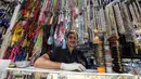 Pedagang mengenakan sarung tangan lateks menunggu pelanggan di tokonya selama bulan suci Ramadhan di Taheran, Iran (25/4/2020). Di pasar ini pedagang dan pembeli beraktivitas mengenakan alat pelindung seperti masker dan sarung tangan akibat pandemi coronavirus COVID-19. (AFP/Atta Kenare)